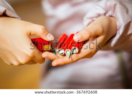 Little girl holding a firecracker. Selective focus.