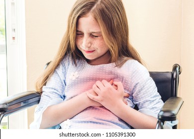 Little Girl Holding Her Chest And Heart Pain Sit On Wheelchair In The Hospital.sick Little Girl.healthcare And Medicine