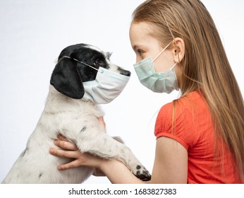 Little girl holding her dog both wearing protective surgical masks caring about her pet performing basic protective measures against transmission of coronavirus COVID-19 disease - Powered by Shutterstock