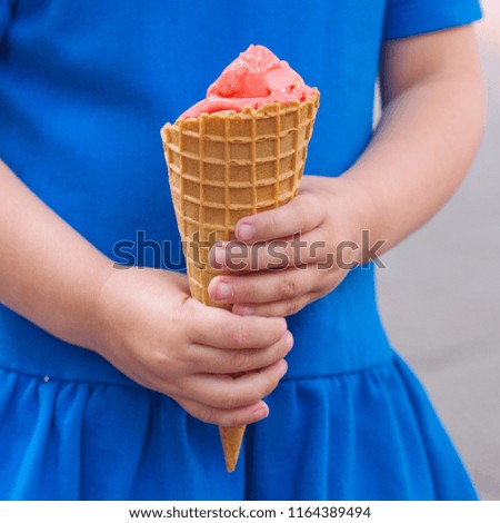 Little girl holding ice cream cone in her hands