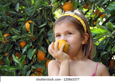 Little girl holding orange