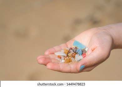 Little girl holding small tiny harmful plastic microbeads collected on the beach in Zante, Zakynthos, Greece