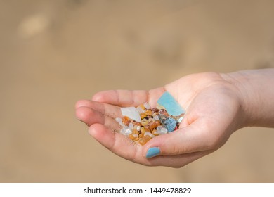 Little girl holding small tiny harmful plastic microbeads collected on the beach in Zante, Zakynthos, Greece