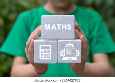 Little girl holding white foam blocks with icons sees word: MATHS. Mathematics education concept. I love math. - Shutterstock ID 2364427933