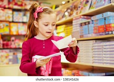 Little girl holds pack of envelopes in one hand and one open envelope in another - Powered by Shutterstock