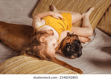 Little Girl At Home On The Couch Playing With Her Big Dog