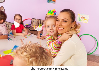 Little girl hug teacher in kindergarten class