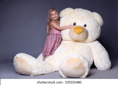 Little Girl Hugging Big Teddy Bear