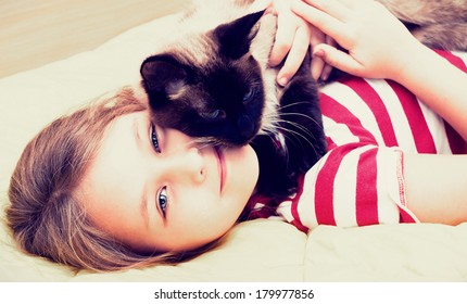 little girl hugging a cat  - Shutterstock ID 179977856
