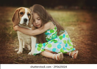 Little Girl Is Hugging  Dog Outdoors