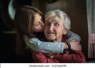 A little girl hugs her grandmother. - Shutterstock ID 1112166590