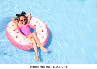 Little Girl With Inflatable Ring In Swimming Pool