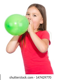 Little girl is inflating green balloon, isolated over white