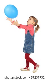 little girl in jeans dress playing with blue balloon side view isolated on white