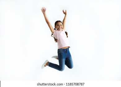 The little girl jumping on the white wall background