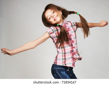  little girl jumps on a gray  background