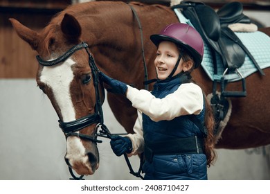 Little girl, kid in helmet taking care after horse, showing her love. Child training horseback riding in special arena, pavilion. Concept of sport, childhood, school, course, active lifestyle, hobby - Powered by Shutterstock