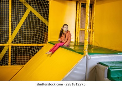 Little girl kid slide at yellow playground park. Child in active entertaiments. - Shutterstock ID 2281812295