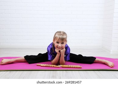 Little girl in kimono doing exercises with nunchaku on wall background - Powered by Shutterstock