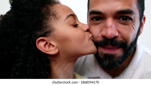 Kleines Mädchen, das den Vater auf die Wange küsst. Papa und Tochter kleben. Familienliebe und Zuneigung