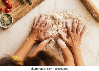 Little girl kneading flour with her mother. Infant Chef Concept. - Powered by Shutterstock