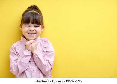 Little Girl Laughing. Caucasian Girl Screw Up Eyes With Laughter, Cute Caucasian Kid In Blouse Isolated Over Yellow Background