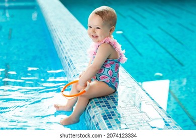 Little Girl Is Laughing In The Pool At A Swimming Lesson.