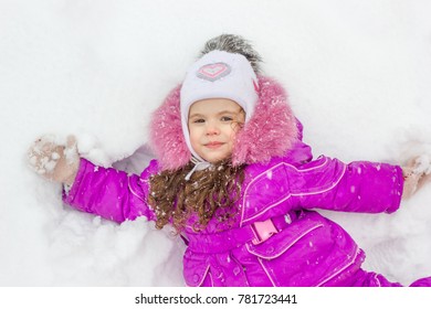 Little girl laying down on a snow