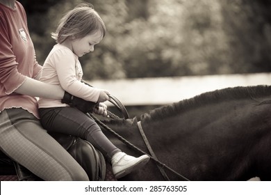 Little girl Learning horseback riding - Powered by Shutterstock