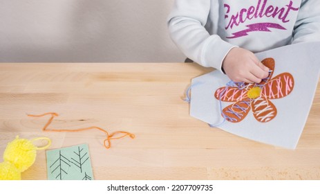 Little Girl Learning How To Sew With Sewing Craft Kit For Kids.