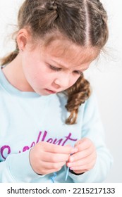 Little Girl Learning How To Sew With Sewing Craft Kit For Kids.