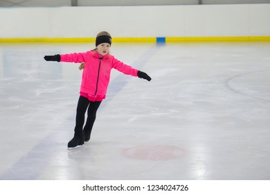 Little Girl Learning To Ice Skate. Figure Skating School. Young Figure Skaters Practicing At Indoor Skating Rink.