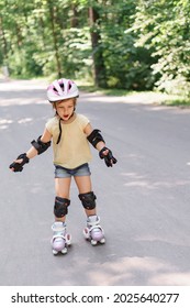 Little Girl Learning To Roller Skate. Kid Girl In Protective Sportswear