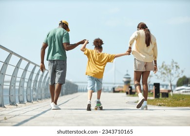 Little girl learning to skateboarding with her parents - Powered by Shutterstock