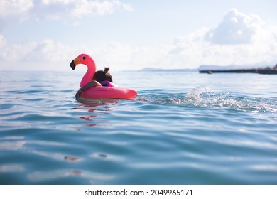 Little girl learning swim at the ocean with floatation device