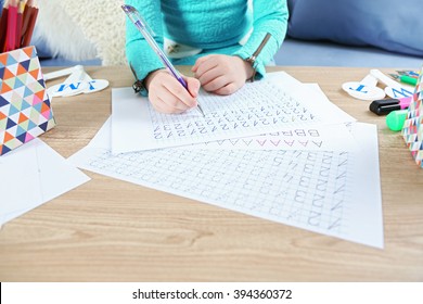 Little Girl Learning To Write Digits At The Table