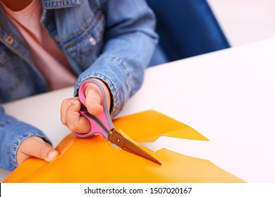 Little Girl Left-handed Cutting Construction Paper At Table, Closeup