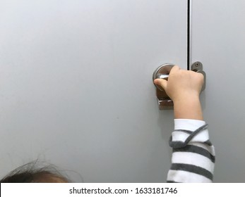 Little Girl Locking Door Knob With Carefully, Close Public Bathroom Door For Safety.