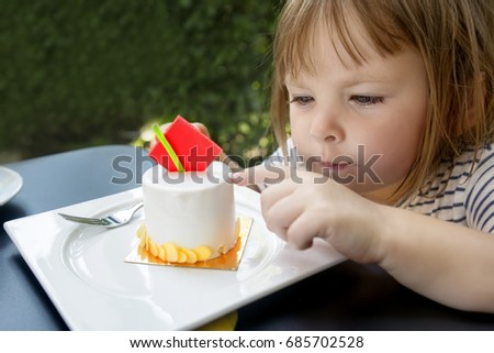 Little girl looking at cake