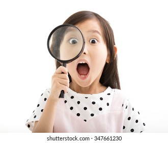little girl looking through a magnifying glass