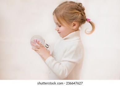 little girl looks at the Magical snow globe - Powered by Shutterstock