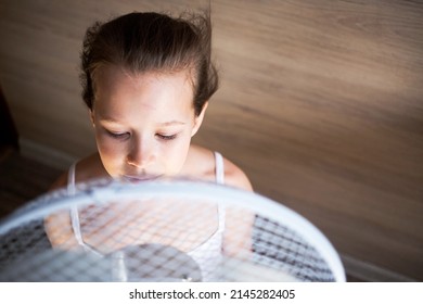 A Little Girl Looks Towards A Large Fan, Hides Behind It And Enjoys The Breeze In The Heat, She Is Blown Away By Wind Currents.