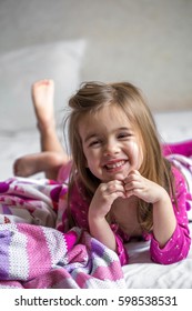 little girl lying on the bed with bare feet ,beautiful smiles,the concept of sleep and rest