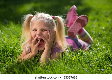 little girl lying on the grass and laughing