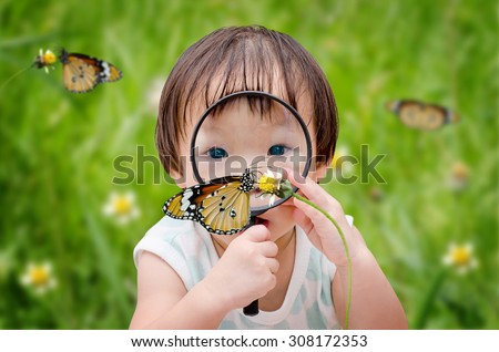  little girl with magnifying glass outdoors in the day time