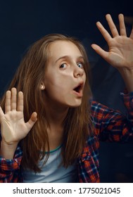 Little Girl Makes Face Leaning Against The Glass