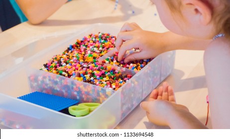 Little Girl Making Bracelet From Colorful Kids Beads.