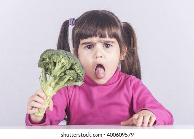 Little Girl Making A Funny Face Refusing To Eat Her Vegetables. Toned Image With Shallow Depth Of Field