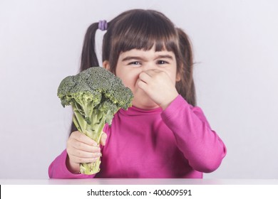 Little Girl Making A Funny Face Refusing To Eat Her Vegetables. Toned Image With Shallow Depth Of Field