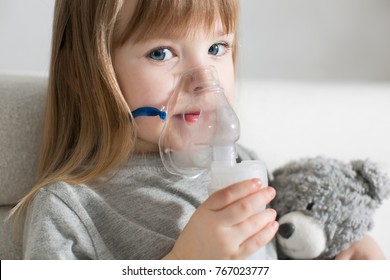 Little girl making inhalation with nebulizer at home. child asthma inhaler inhalation nebulizer steam sick cough concept Horizontal - Powered by Shutterstock